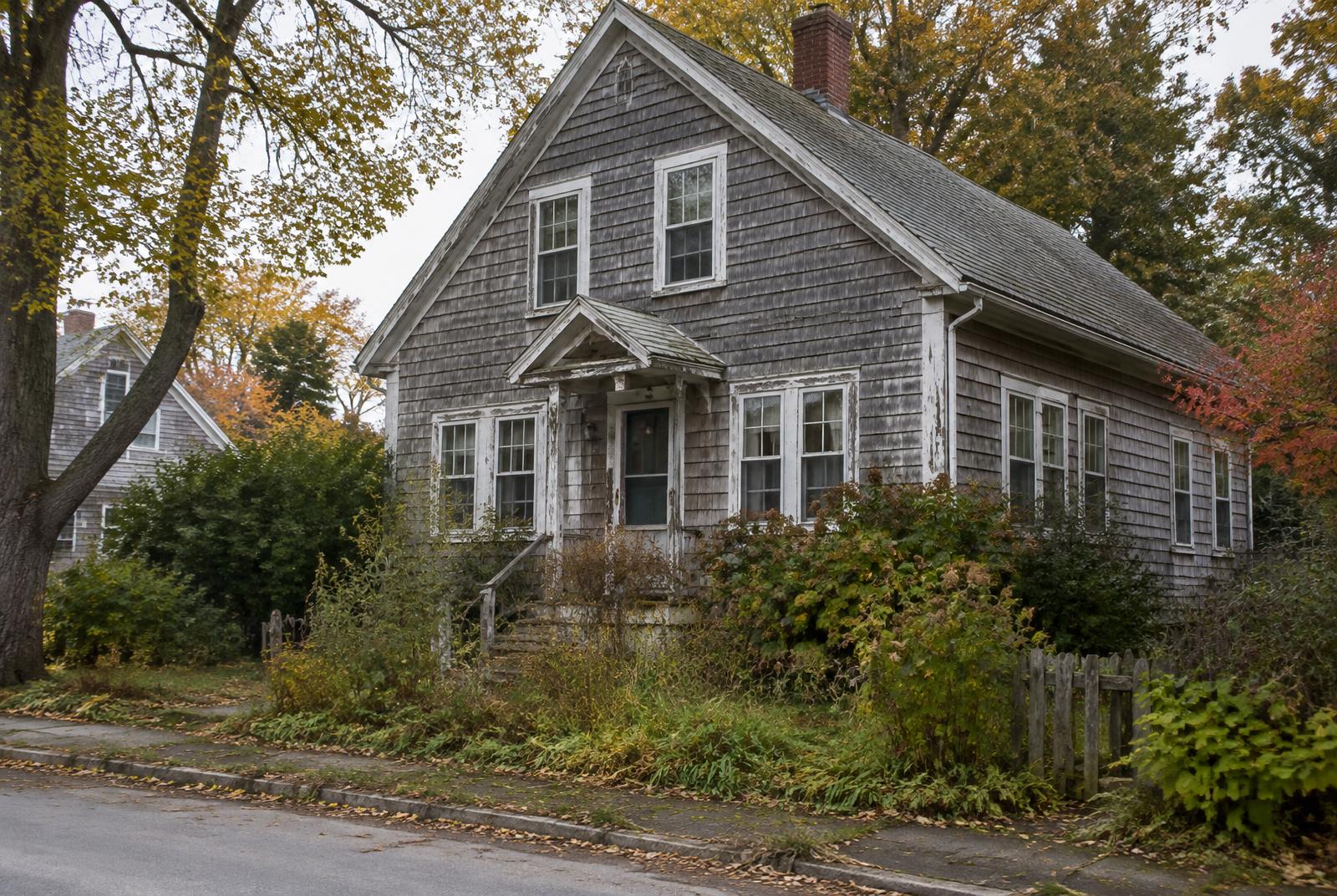 A weathered New England single-family home in need of repair